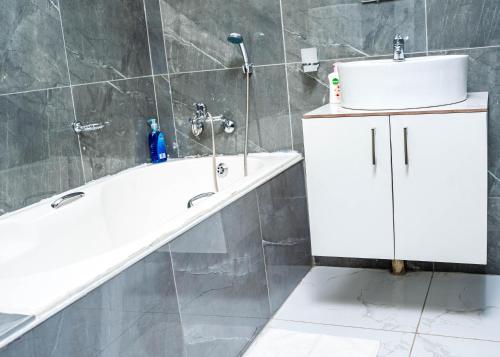 AKEMS MOTEL في كيمبتون بارك: حمام مع حوض استحمام ومغسلة