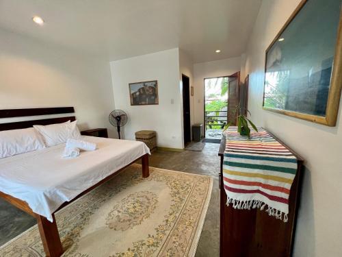 a bedroom with a bed and a rug at Fat Lips Surf Lodge in General Luna