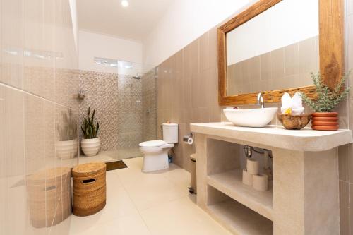 a bathroom with a sink and a toilet at CASTELU 3BR peacefully villa near Mertanadi in Seminyak