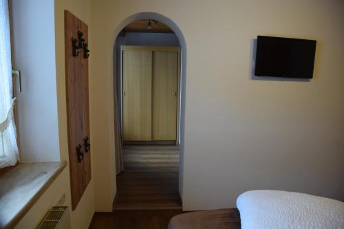 a room with a hallway with a door and a television at Haus Weitenstich in Zell am Ziller