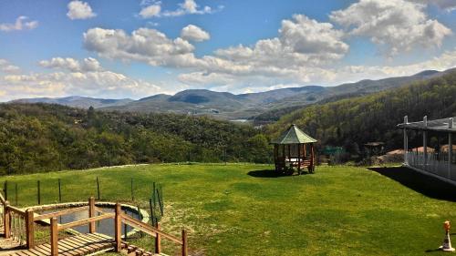 un gazebo in un campo con le montagne sullo sfondo di Zumrut Bahce a Gokcedere