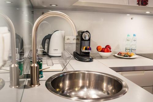 eine Küche mit einer Edelstahlspüle in der Küche in der Unterkunft Apartamenty Straszewskiego in Krakau