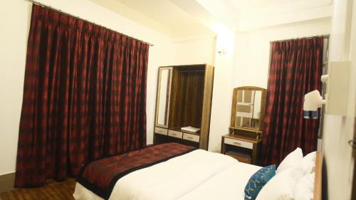 a hotel room with a bed and a window at Pink Rose Homestay in Gangtok
