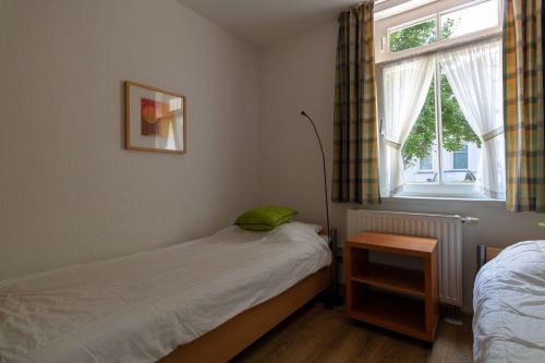 ein kleines Schlafzimmer mit einem Bett und einem Fenster in der Unterkunft Villa Eden Binz Typ 5 (Apt.14) in Binz