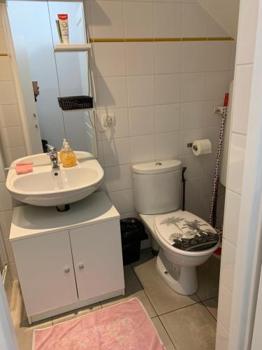 a small bathroom with a toilet and a sink at La Maison des roses in Nanterre