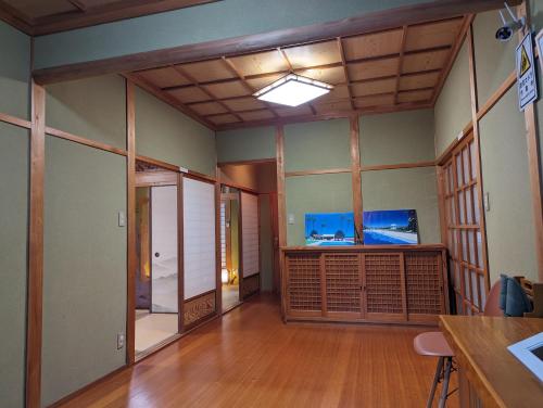a room with wooden floors and a room with glass walls at 龍のお宿 in Nio