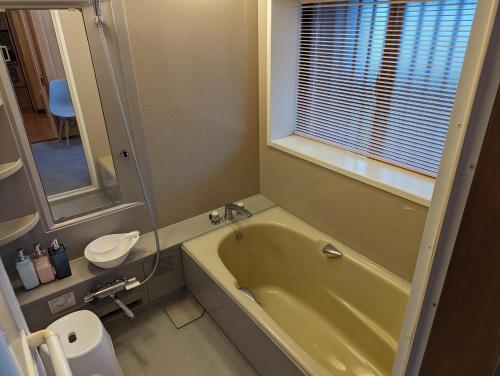 a bathroom with a green tub and a toilet at 龍のお宿 in Nio