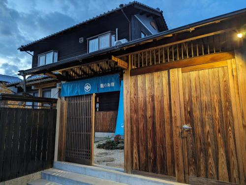 a house with wooden gates in front of it at 龍のお宿 in Nio
