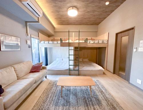 a living room with a couch and bunk beds at Rakuten STAY Fukuoka Yakuin Family Room in Fukuoka