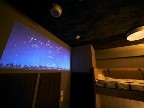 um ecrã de projecção num quarto com uma cama em Rakuten STAY Fukuoka Yakuin Family Room em Fukuoka