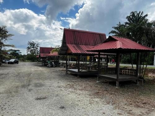 a group of buildings with red roofs on a road at Ayem Homestay Parit Raja Darat in Parit Raja
