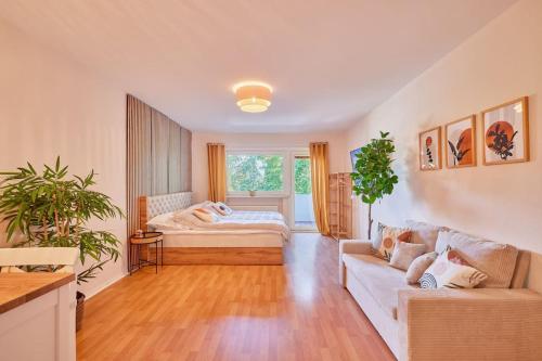 - un salon avec un lit et un canapé dans l'établissement *Design Studio nahe Frankfurt Bahnhof & Flughafen*, à Neulsenburg