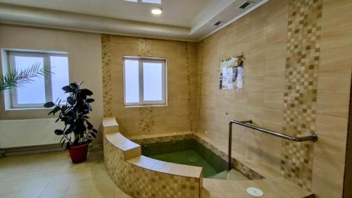 baño grande con bañera con agua verde en Zabava Guest House, en Ivano-Frankivsk