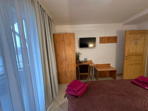 a bedroom with a bed and a desk and a television at Brauner Bär mit Donaublick in Altenberg