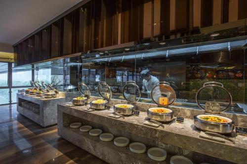 a kitchen with a chef preparing food in a restaurant at Hilton Garden Inn Ningbo in Ningbo