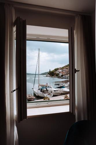 a window with a view of a boat in the water at Adriana Zaton in Zaton