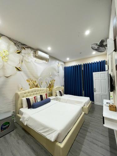 a bedroom with two beds and a flower wall at Khách sạn Hướng Dương in Hanoi