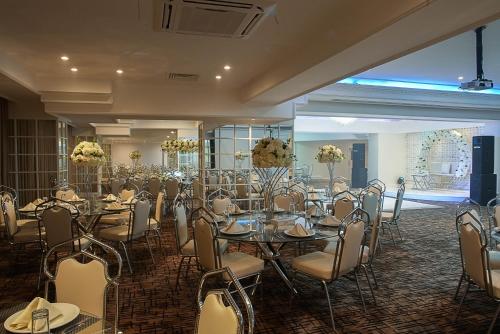 um salão de banquetes com mesas e cadeiras numa sala em Toledo Amman Hotel em Amã