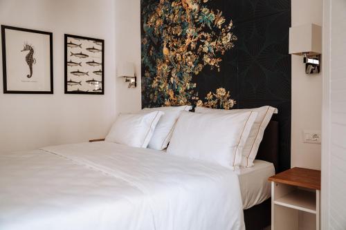a bedroom with a white bed with a painting on the wall at Adriana Zaton in Zaton