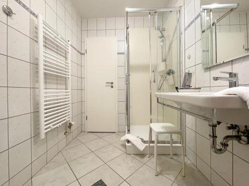 a white bathroom with a sink and a shower at Ferienwohnung Neptun FeWo 01 - Terrasse, Garten in Drewoldke
