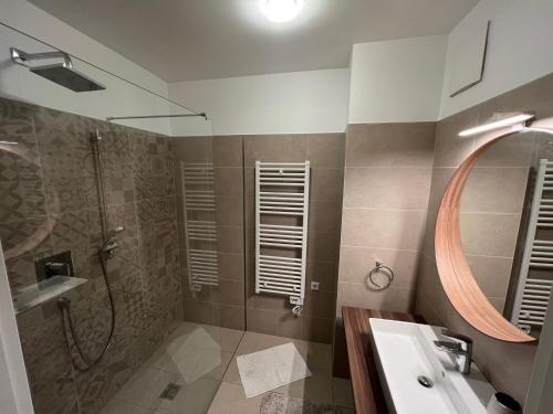 een badkamer met een douche, een wastafel en een spiegel bij Ferienwohnung Isenberg in Bad Reichenhall