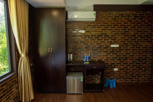 a room with a brick wall and a trash can at Mandarin Homestay Hue in Hue