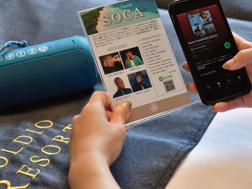 a person holding a cell phone and a newspaper at Music Hotel Koza by Coldio Premium in Okinawa City