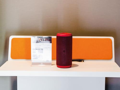 a red speaker sitting on top of a white table at Music Hotel Koza by Coldio Premium in Okinawa City