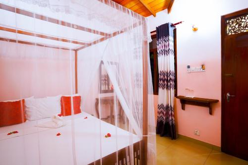 Habitación con baño con cortina de ducha blanca. en Frangipani motel, en Galle