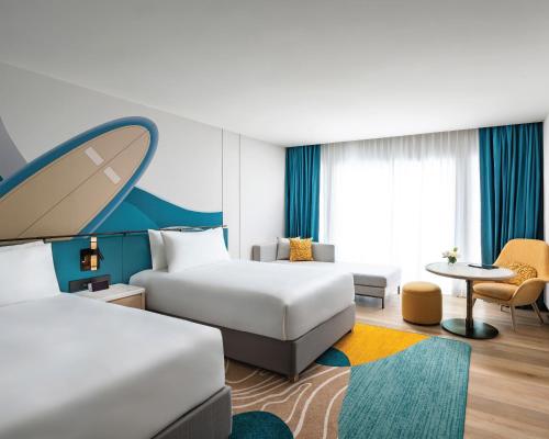 a hotel room with a bed and a table at M Social Hotel Phuket in Patong Beach