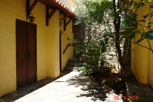 an alley with a door and a tree next to a building at Rigas Hotel Arachova in Arachova