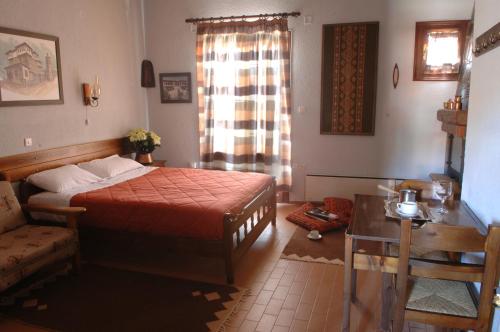 a bedroom with a bed and a couch and a window at Rigas Hotel Arachova in Arachova