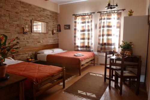 a bedroom with two beds and a table and chairs at Rigas Hotel Arachova in Arachova