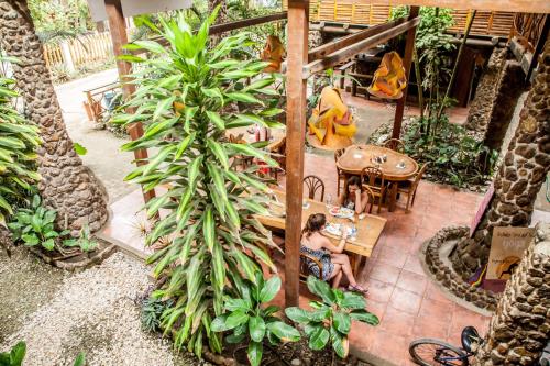 a woman sitting at a table in a garden at Casa del Sol in Montañita