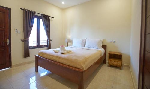 a bedroom with a bed with a stuffed animal on it at Risna Homestay in Nusa Lembongan