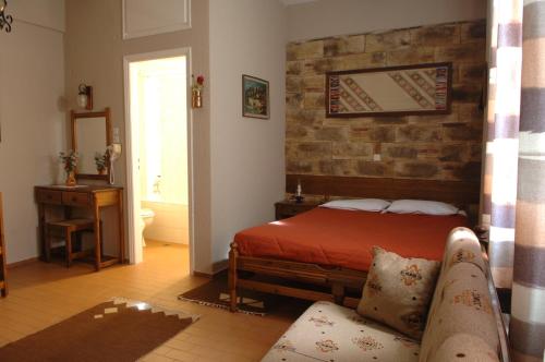 a bedroom with a bed and a brick wall at Rigas Hotel Arachova in Arachova