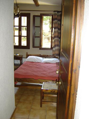 a bedroom with a bed and two windows and a door at Rigas Hotel Arachova in Arachova