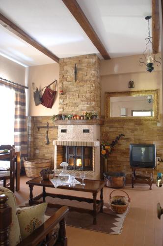 a living room with a fireplace and a tv at Rigas Hotel Arachova in Arachova
