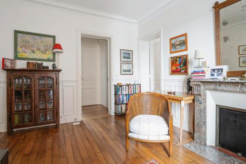 - un salon avec une cheminée et une chaise dans l'établissement Appartement Mélèze - Welkeys, à Paris