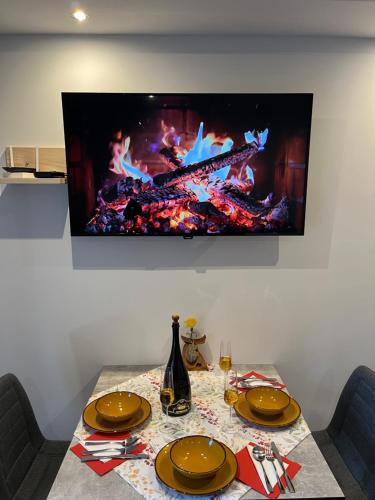 a table with plates and a television on a wall at Apartment & Studio Forest Paradise in Cerkno