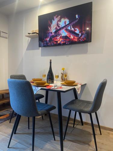 a dining room table with chairs and a tv on the wall at Apartment & Studio Forest Paradise in Cerkno