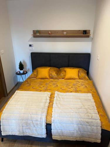 a bed with two pillows on it in a bedroom at Apartment & Studio Forest Paradise in Cerkno