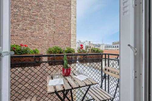 une table avec une plante en pot sur un balcon dans l'établissement Appartement Mélèze - Welkeys, à Paris