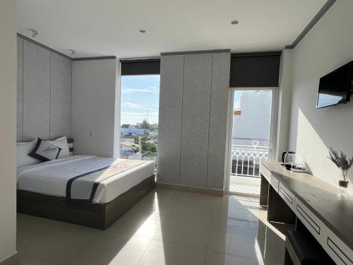 a bedroom with a bed and a view of the ocean at Lavender Muine Hotel in Mui Ne