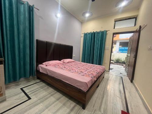 1 dormitorio con cama y cortinas verdes en Deepak Homestay en Rishīkesh