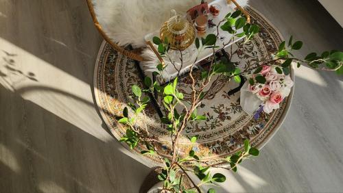 a cat sitting on a table next to a vase with flowers at Pension Haneul Tari in Jeju