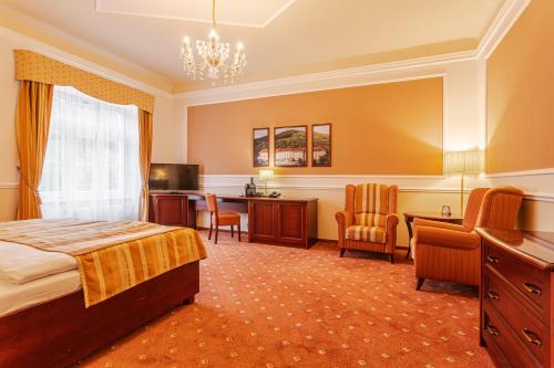 a hotel room with a bed and a desk at Hotel Radium Palace in Jáchymov