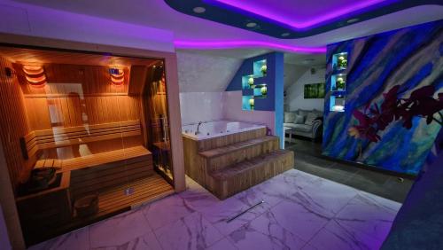 d'une grande salle de bains avec baignoire et d'escaliers avec éclairage violet. dans l'établissement Vila Argola - Spa Luxury Apartments 2023, à Belgrade