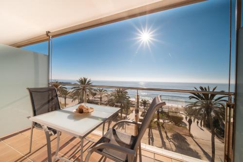 a table and chairs on a balcony with a view of the beach at Calipolis in Sitges