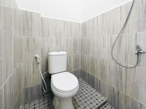 a bathroom with a toilet and a shower at RedDoorz near Stasiun Pematangsiantar in Pematangsiantar